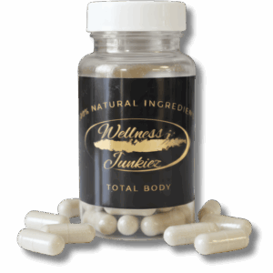 Wellness Junkiez Total Body natural dietary supplement bottle with white ribbed cap and herbal capsules scattered at the base on a white background.