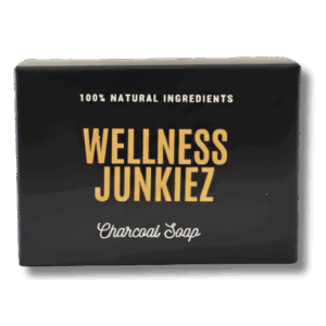 A packaged bar of Wellness Junkiez Charcoal Detox Soap with elegant gold and white lettering on a black box.