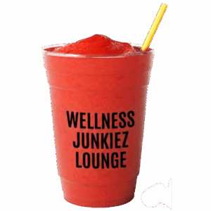 Vibrant red Watermelon Rehab smoothie in a clear cup with Wellness Junkiez Lounge logo, yellow straw, and fresh watermelon slices on a white background.